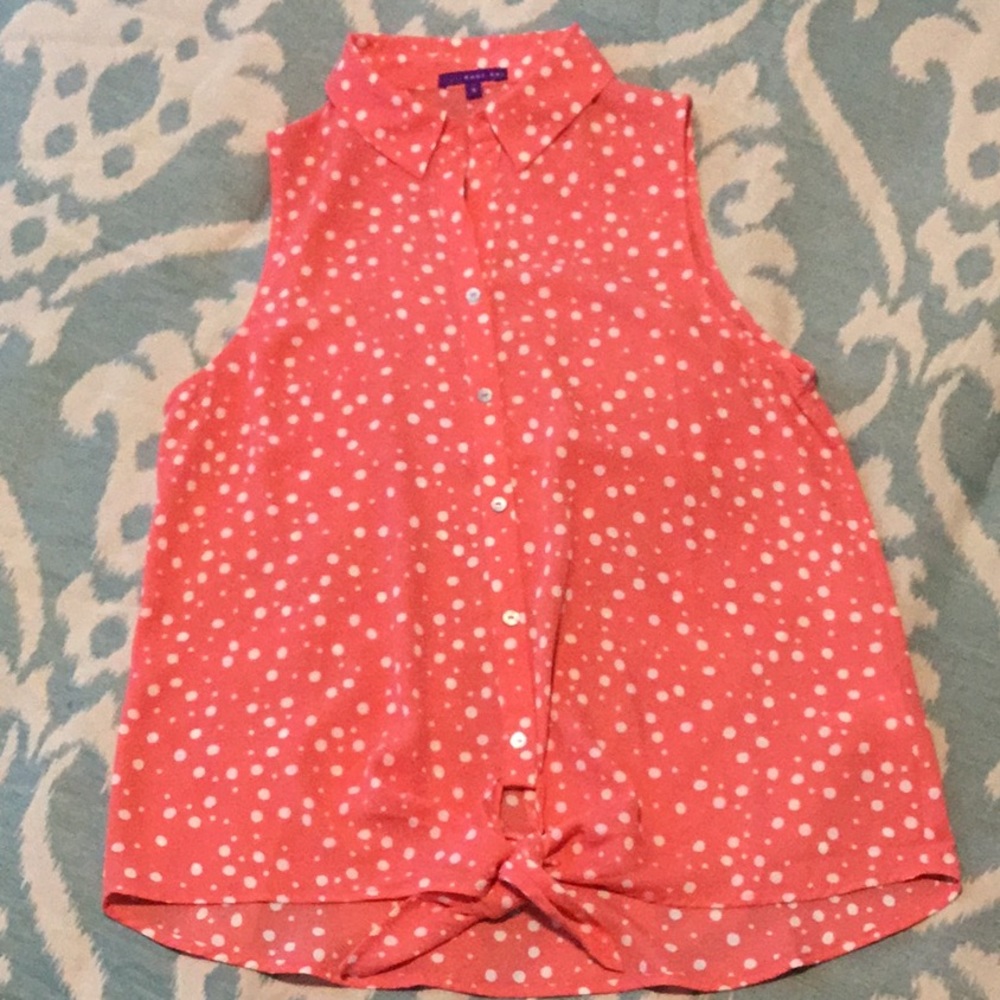Coral colored white polka-dotted blouse with button front and tie closure.